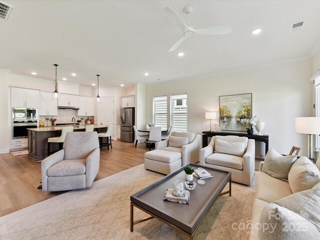 1120 Idyllic Ln, Waxhaw, NC 28173 - living area with light wood-style flooring, recessed lighting, a ceiling fan, and ornamental molding