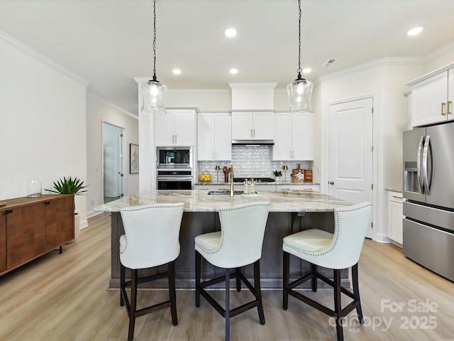 1120 Idyllic Ln, Waxhaw, NC 28173 - kitchen featuring appliances with stainless steel finishes, decorative backsplash, ornamental molding, light wood-type flooring, and white cabinets