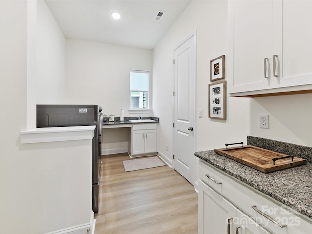 1120 Idyllic Ln, Waxhaw, NC 28173 - kitchen with white cabinetry, dark stone counters, light wood-style flooring, and recessed lighting
