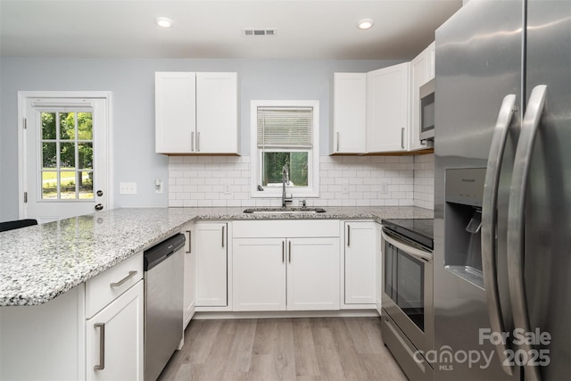 213 Pinewood Dr, Grover, NC 28073 - kitchen featuring stainless steel appliances, a peninsula, white cabinetry, light wood-type flooring, and light stone countertops