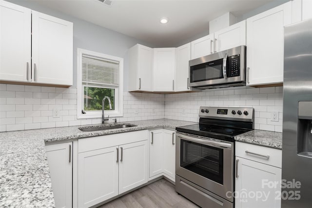 213 Pinewood Dr, Grover, NC 28073 - kitchen featuring appliances with stainless steel finishes, white cabinets, tasteful backsplash, light stone countertops, and recessed lighting