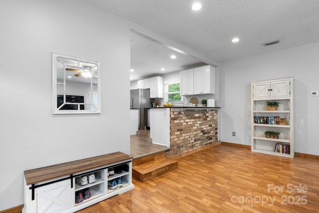50 Isenhour Park Rd, Taylorsville, NC 28681 - kitchen featuring freestanding refrigerator, dark countertops, white cabinetry, a peninsula, and light wood-type flooring