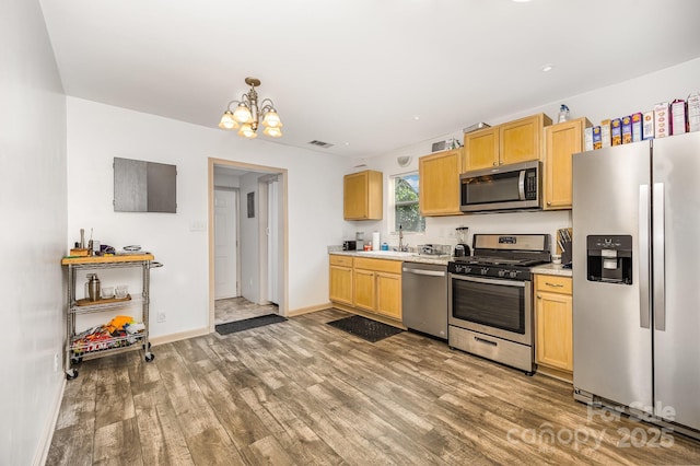 1019 Richard St, Salisbury, NC 28144 - kitchen with stainless steel appliances, light countertops, a chandelier, light wood-type flooring, and light brown cabinets