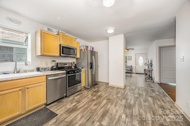 1019 Richard St, Salisbury, NC 28144 - kitchen with appliances with stainless steel finishes, light wood-type flooring, light countertops, and light brown cabinetry