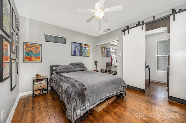 1019 Richard St, Salisbury, NC 28144 - bedroom with a barn door, wood finished floors, ceiling fan, and a closet