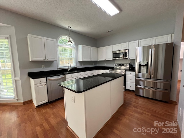 2609 Lamp Post Ln, Kannapolis, NC 28081 - kitchen with appliances with stainless steel finishes, dark wood-style floors, white cabinets, dark countertops, and a textured ceiling