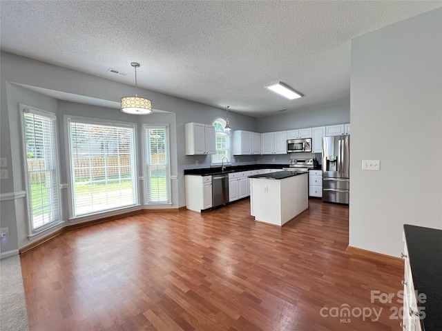 2609 Lamp Post Ln, Kannapolis, NC 28081 - kitchen featuring stainless steel appliances, dark wood-style floors, a textured ceiling, dark countertops, and white cabinets