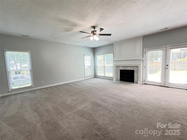 2609 Lamp Post Ln, Kannapolis, NC 28081 - unfurnished living room featuring carpet floors, a ceiling fan, healthy amount of natural light, a textured ceiling, and a high end fireplace