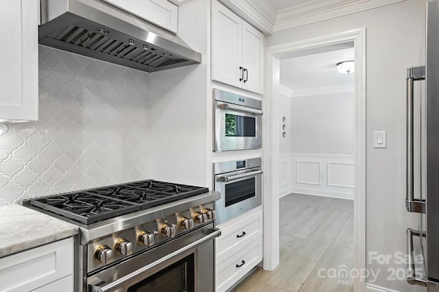 4825 Deanscroft Dr, Charlotte, NC 28226 - kitchen featuring ventilation hood, appliances with stainless steel finishes, ornamental molding, white cabinets, and tasteful backsplash