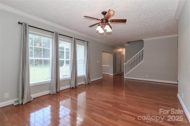 5890 Alley Rd, Catawba, NC 28609 - spare room featuring wood finished floors, ceiling fan, stairs, a textured ceiling, and ornamental molding