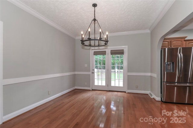 5890 Alley Rd, Catawba, NC 28609 - unfurnished dining area featuring a chandelier, wood-type flooring, a textured ceiling, arched walkways, and ornamental molding