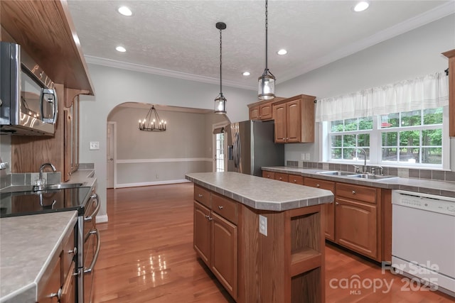 5890 Alley Rd, Catawba, NC 28609 - kitchen with appliances with stainless steel finishes, a center island, ornamental molding, arched walkways, and brown cabinets