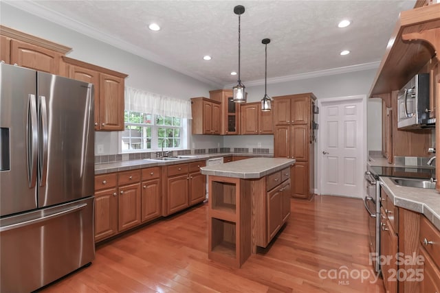 5890 Alley Rd, Catawba, NC 28609 - kitchen with stainless steel appliances, brown cabinets, a kitchen island, light wood-style flooring, and glass insert cabinets
