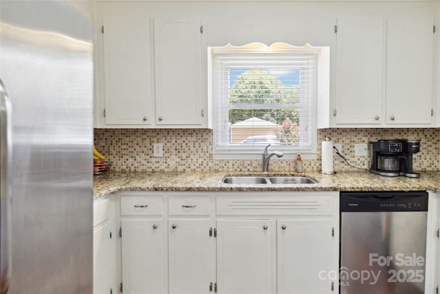 1219 Flowe Dr, Matthews, NC 28104 - kitchen featuring appliances with stainless steel finishes, white cabinetry, decorative backsplash, and light stone counters
