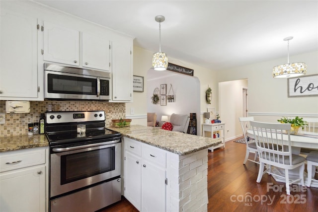 1219 Flowe Dr, Matthews, NC 28104 - kitchen featuring appliances with stainless steel finishes, a peninsula, white cabinets, and tasteful backsplash