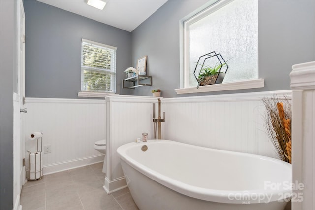 1219 Flowe Dr, Matthews, NC 28104 - bathroom with a wainscoted wall, a soaking tub, and tile patterned floors