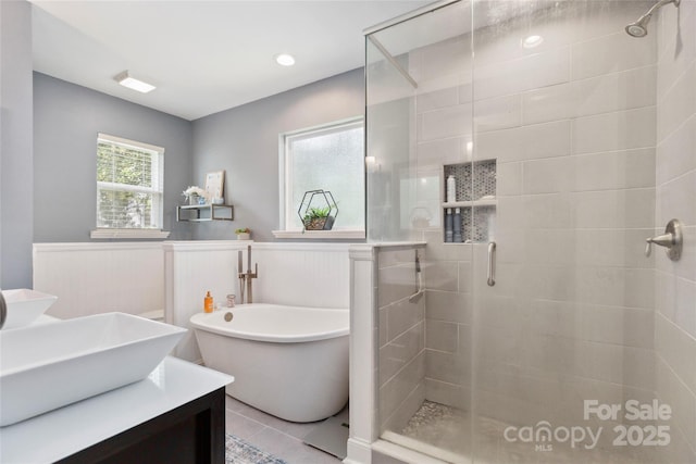 1219 Flowe Dr, Matthews, NC 28104 - bathroom featuring a shower stall, a soaking tub, wainscoting, and vanity