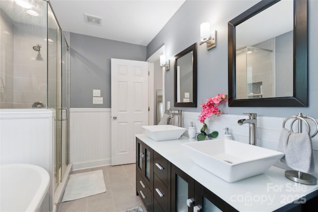 1219 Flowe Dr, Matthews, NC 28104 - bathroom featuring a shower stall, double vanity, tile patterned floors, a tub to relax in, and wainscoting