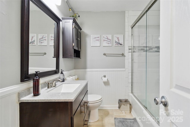 1219 Flowe Dr, Matthews, NC 28104 - bathroom with a wainscoted wall, vanity, combined bath / shower with glass door, tile patterned flooring, and a decorative wall