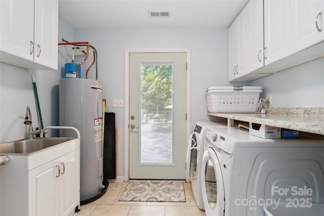 1219 Flowe Dr, Matthews, NC 28104 - washroom featuring electric water heater, washing machine and clothes dryer, cabinet space, and light tile patterned floors