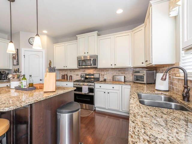 1109 Saratoga Blvd, Indian Trail, NC 28079 - kitchen featuring stainless steel appliances, a breakfast bar, dark wood-type flooring, decorative backsplash, and recessed lighting