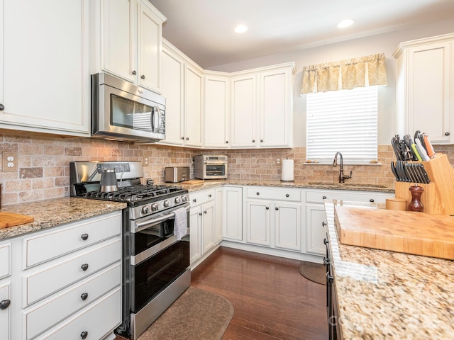 1109 Saratoga Blvd, Indian Trail, NC 28079 - kitchen featuring stainless steel appliances, dark wood finished floors, decorative backsplash, light stone counters, and white cabinetry