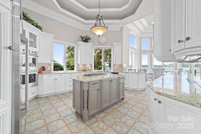 3394 Governors Island Dr, Denver, NC 28037 - kitchen with a tray ceiling, healthy amount of natural light, decorative backsplash, white cabinets, and crown molding