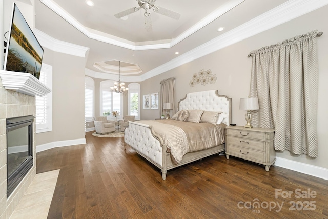 3394 Governors Island Dr, Denver, NC 28037 - bedroom featuring a tray ceiling, a chandelier, crown molding, wood finished floors, and a tiled fireplace