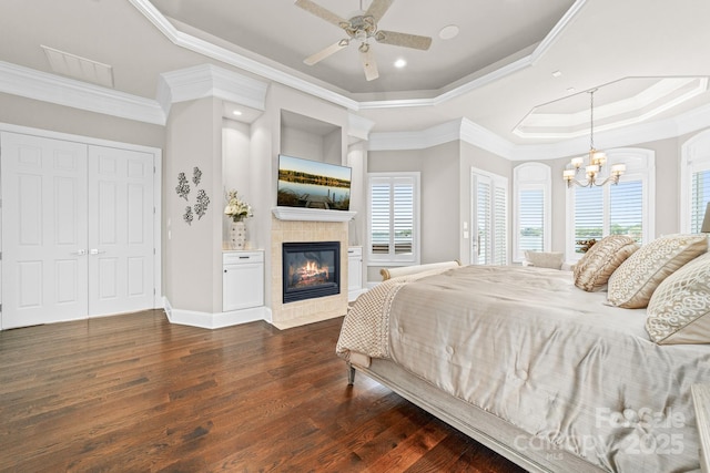 3394 Governors Island Dr, Denver, NC 28037 - bedroom with a tray ceiling, a chandelier, dark wood-style floors, ornamental molding, and a tiled fireplace