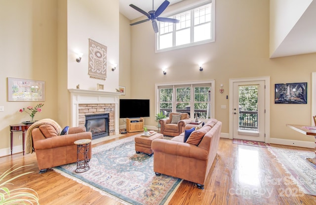 35 Village Pointe Ln, Asheville, NC 28803 - living area featuring wood finished floors, a fireplace, ceiling fan, healthy amount of natural light, and a high ceiling