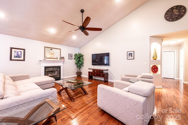 3889 Mattingly Dr, Hickory, NC 28602 - living area with ceiling fan, high vaulted ceiling, hardwood / wood-style flooring, a glass covered fireplace, and a textured ceiling