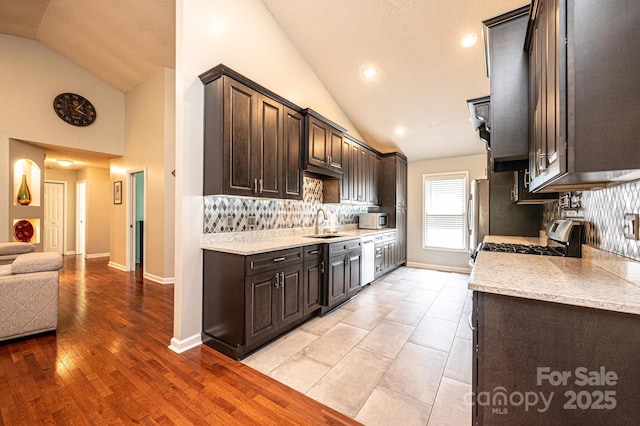 3889 Mattingly Dr, Hickory, NC 28602 - kitchen featuring stainless steel appliances, dark brown cabinets, tasteful backsplash, high vaulted ceiling, and recessed lighting
