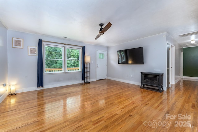 24 Arco Rd, Asheville, NC 28805 - unfurnished living room featuring a wood stove, light wood finished floors, and ceiling fan