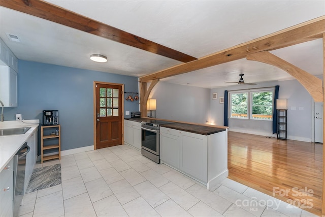 24 Arco Rd, Asheville, NC 28805 - kitchen with stainless steel appliances, beamed ceiling, ceiling fan, open floor plan, and a peninsula