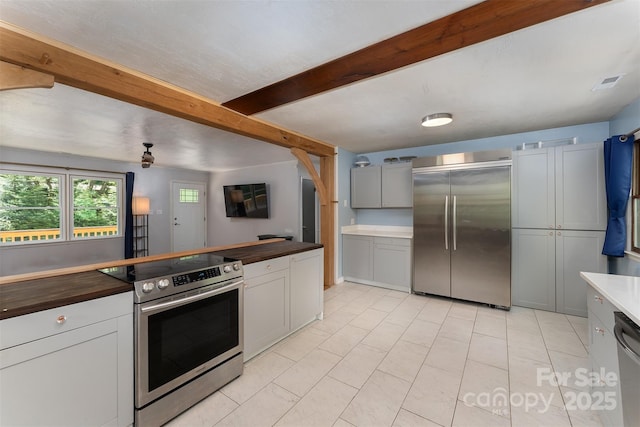 24 Arco Rd, Asheville, NC 28805 - kitchen featuring appliances with stainless steel finishes, butcher block countertops, beam ceiling, and light tile patterned floors