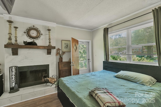 2008 Kimway Dr, Matthews, NC 28105 - bedroom featuring a textured ceiling, wood finished floors, ornamental molding, and a tiled fireplace