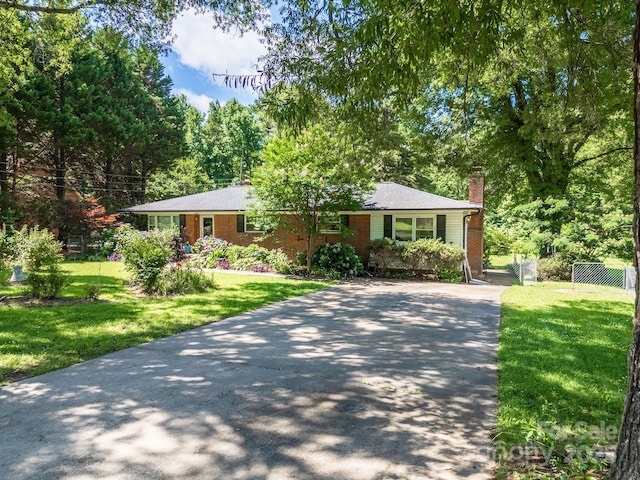 2008 Kimway Dr, Matthews, NC 28105 - view of front of home with a chimney, driveway, brick siding, and view of wooded area