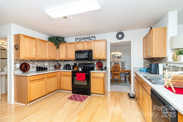 6619 Bittinger Ct, Charlotte, NC 28216 - kitchen featuring black appliances, light wood finished floors, tasteful backsplash, and light countertops