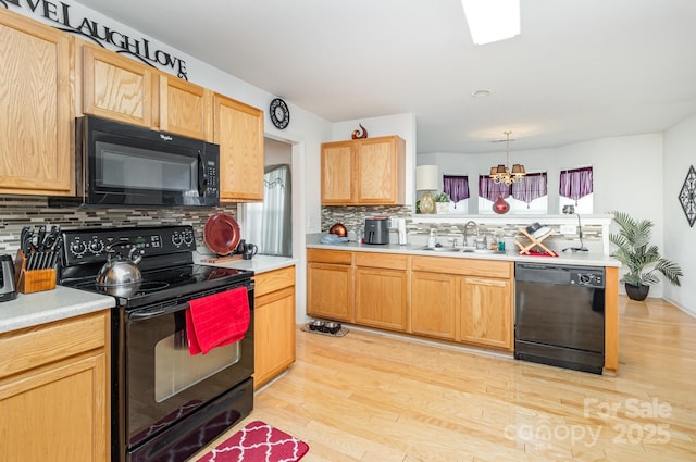 6619 Bittinger Ct, Charlotte, NC 28216 - kitchen with black appliances, tasteful backsplash, light countertops, and light wood-style flooring