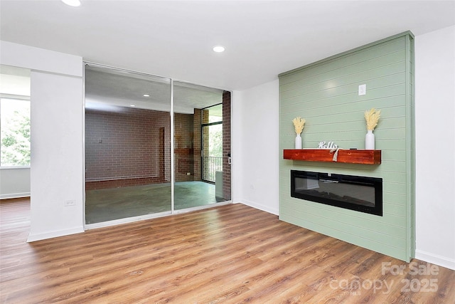 1300 Queens Rd Unit 405, Charlotte, NC 28207 - unfurnished living room featuring wood finished floors, recessed lighting, and a glass covered fireplace