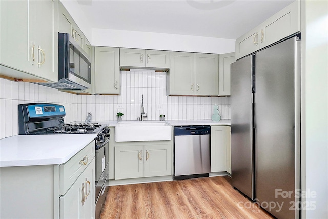 1300 Queens Rd Unit 405, Charlotte, NC 28207 - kitchen with stainless steel appliances, gray cabinetry, light countertops, light wood finished floors, and tasteful backsplash