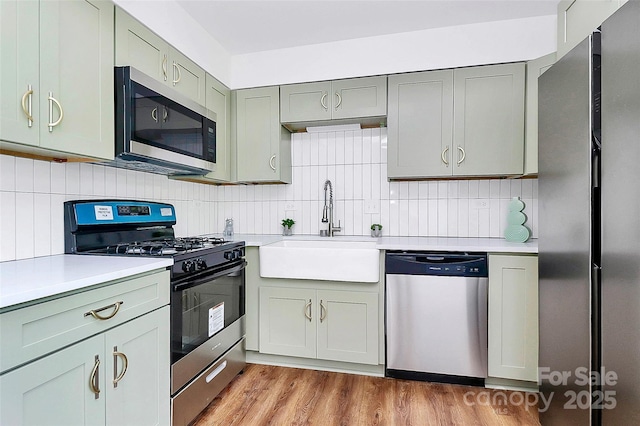 1300 Queens Rd Unit 405, Charlotte, NC 28207 - kitchen featuring appliances with stainless steel finishes, light countertops, tasteful backsplash, and light wood-type flooring