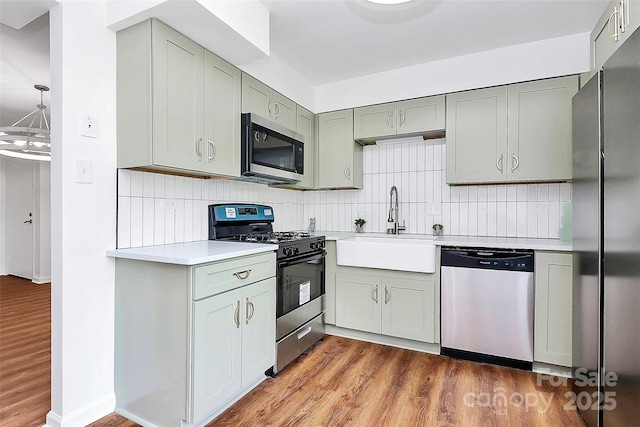 1300 Queens Rd Unit 405, Charlotte, NC 28207 - kitchen with appliances with stainless steel finishes, light countertops, tasteful backsplash, and wood finished floors