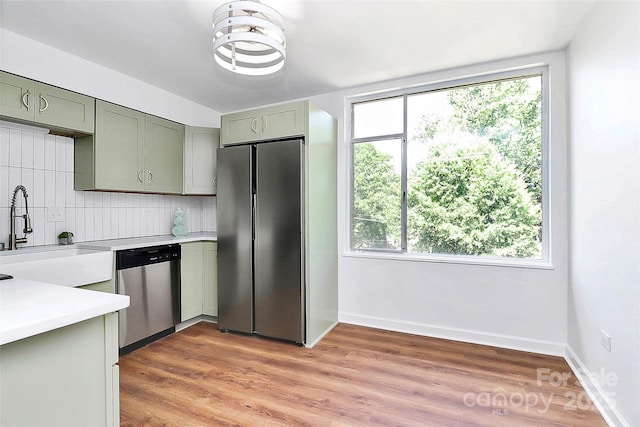 1300 Queens Rd Unit 405, Charlotte, NC 28207 - kitchen with stainless steel appliances, light countertops, decorative backsplash, and light wood finished floors