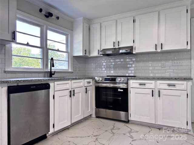218 Hartman St, Gastonia, NC 28052 - kitchen with appliances with stainless steel finishes, under cabinet range hood, light marble finish flooring, white cabinetry, and ornamental molding
