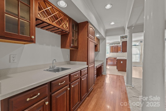 322 Oakview Dr, Salisbury, NC 28146 - kitchen featuring crown molding, light countertops, glass insert cabinets, recessed lighting, and light wood-style floors