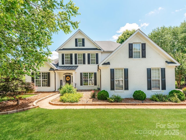 1605 Ambergate Dr, Waxhaw, NC 28173 - traditional-style home with brick siding, a front lawn, a standing seam roof, and a metal roof