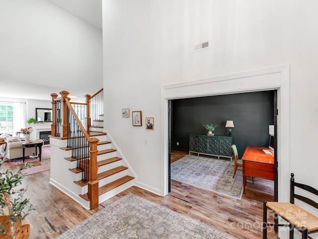 1605 Ambergate Dr, Waxhaw, NC 28173 - stairs with wood finished floors, a fireplace, and a towering ceiling