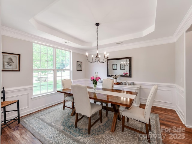 1605 Ambergate Dr, Waxhaw, NC 28173 - dining room with a raised ceiling, wood finished floors, a chandelier, wainscoting, and a decorative wall