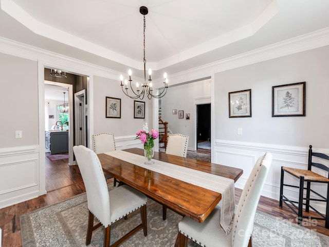 1605 Ambergate Dr, Waxhaw, NC 28173 - dining room featuring a chandelier, a raised ceiling, wood finished floors, a wainscoted wall, and crown molding